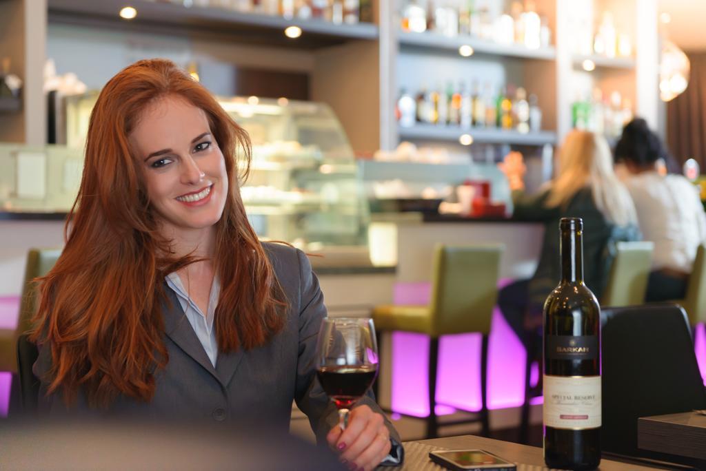 Leonardo City Tower Hotel Tel Aviv Giv'atayim Exteriör bild A woman drinking wine