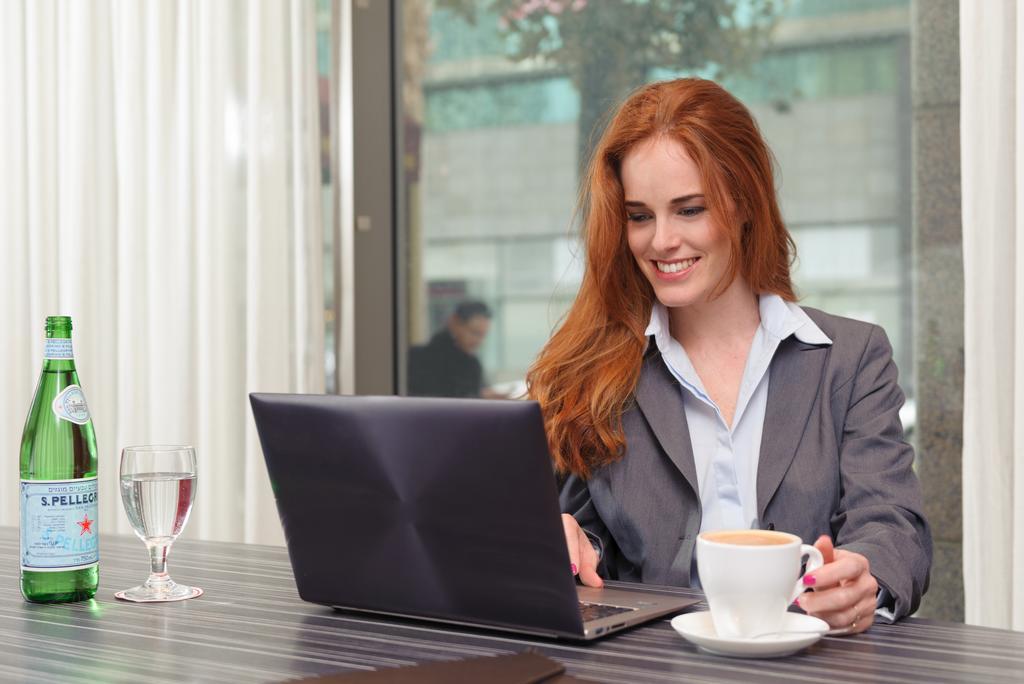 Leonardo City Tower Hotel Tel Aviv Giv'atayim Exteriör bild A woman working on a laptop
